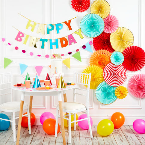 Pink and gold birthday decorations with balloons and bunting.